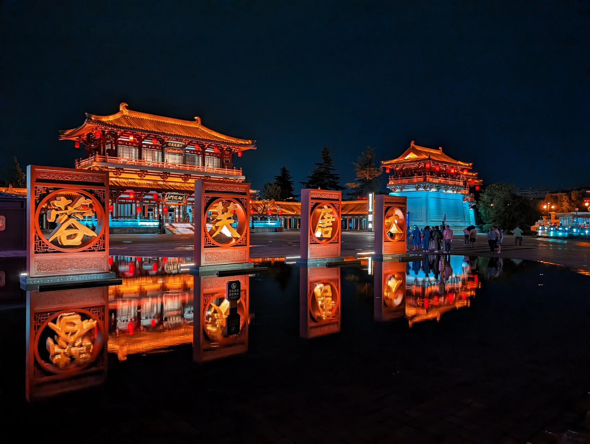 Ornate illuminated gateways reflected in dark water